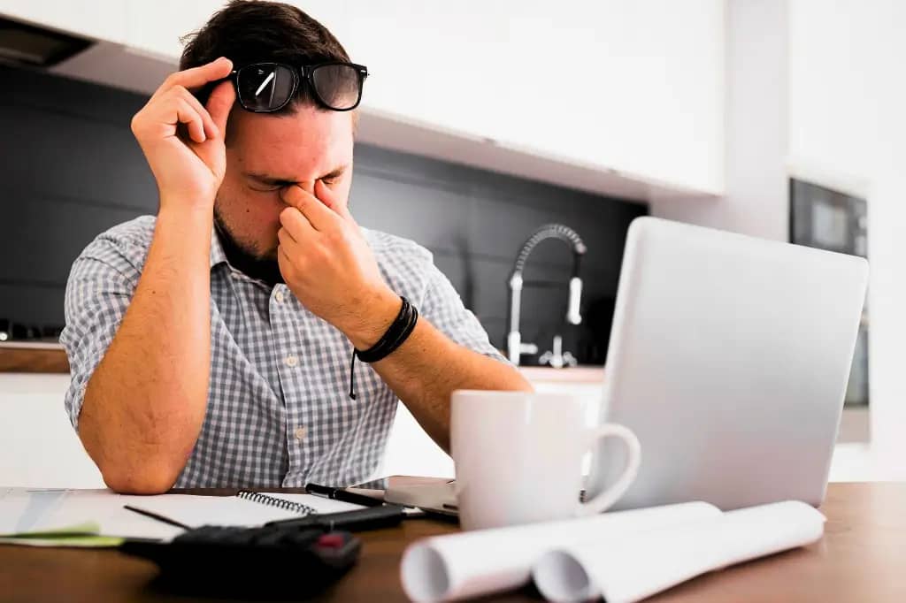 Person experiencing Computer Vision Syndrome while using a computer screen